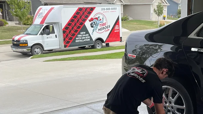 Tire Heroes technician installing new tires in a customer's driveway in Des Moines